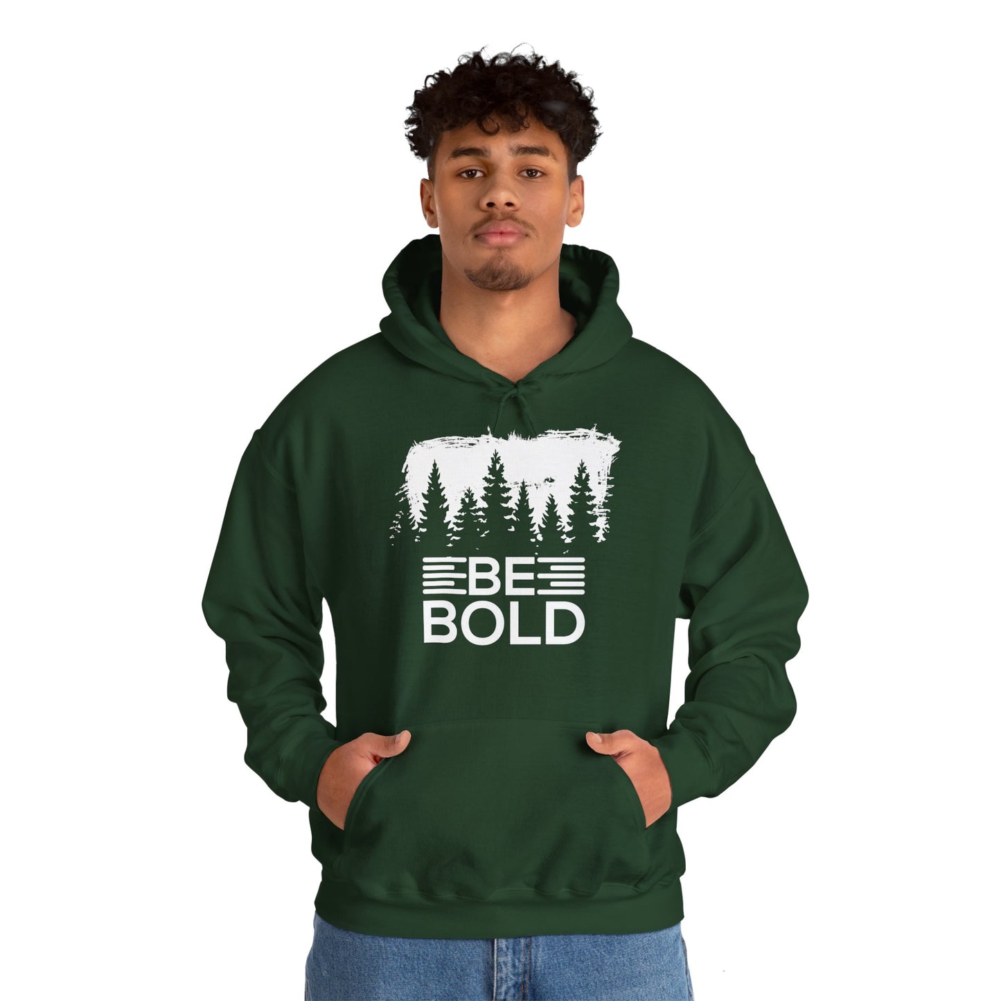 A person wearing a green unisex hooded sweatshirt with 'BE BOLD' text and a forest and pine tree design.