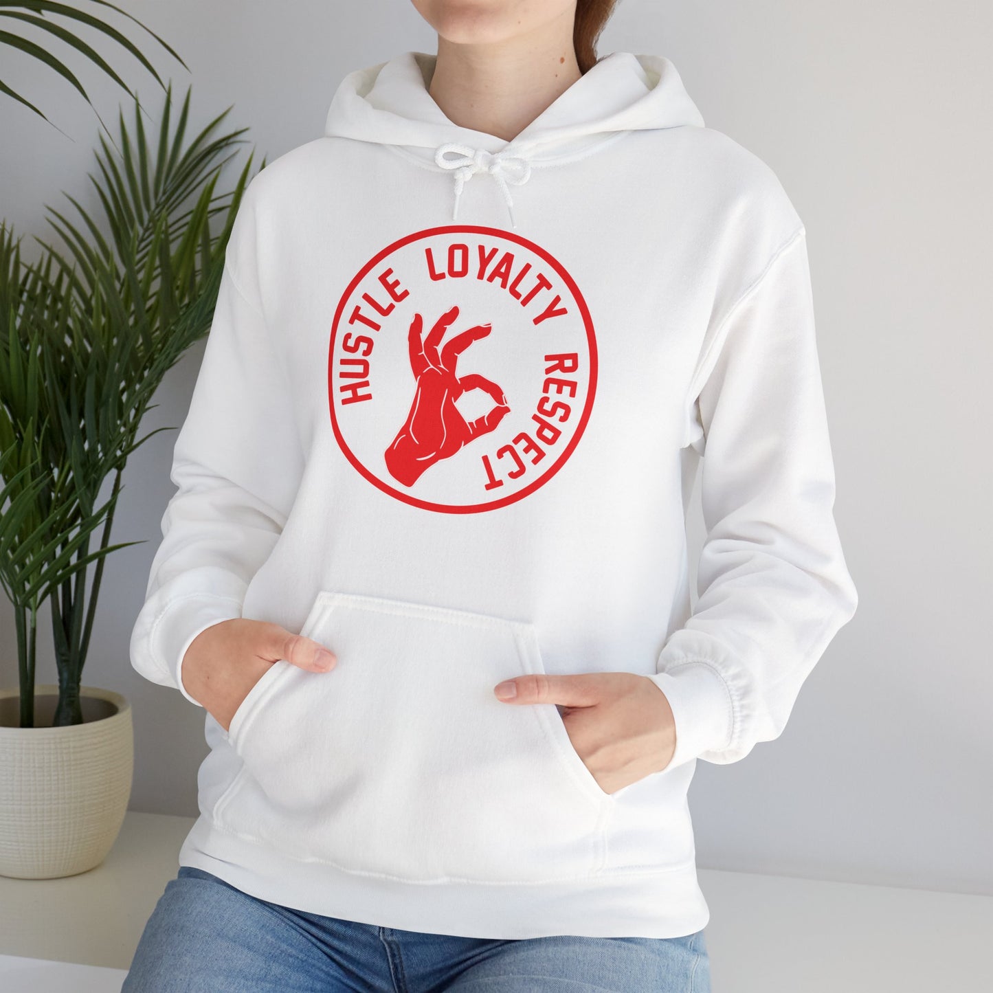 A person wearing a white unisex hooded sweatshirt with 'HUSTLE LOYALTY RESPECT' printed in red on the front.