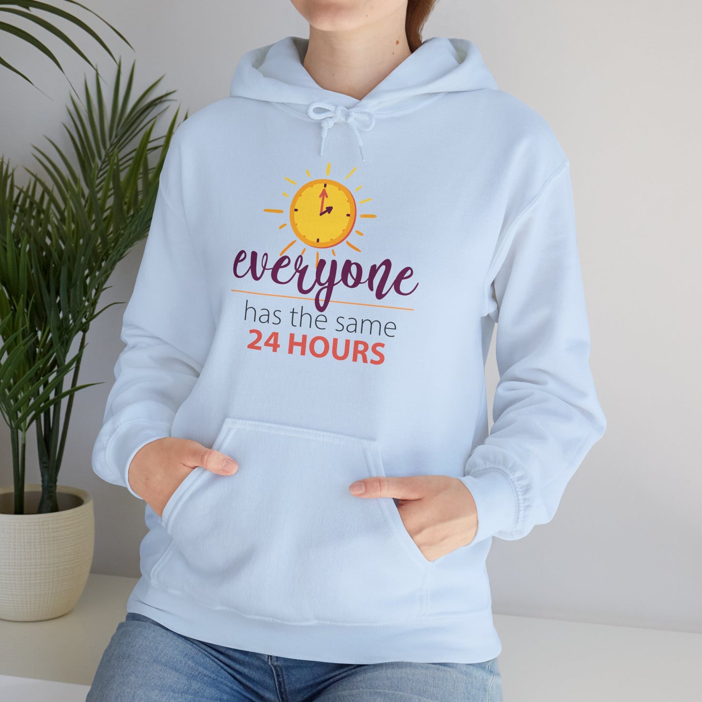 A person wearing a blue hooded sweatshirt with the text 'EVERYONE HAS THE SAME 24 HOURS' printed on the front.
