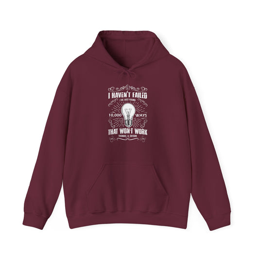 A maroon unisex hooded sweatshirt with a text design on the front stating 'I Haven't Failed, I've just found 10,000 ways that won't work' by Thomas Edison.