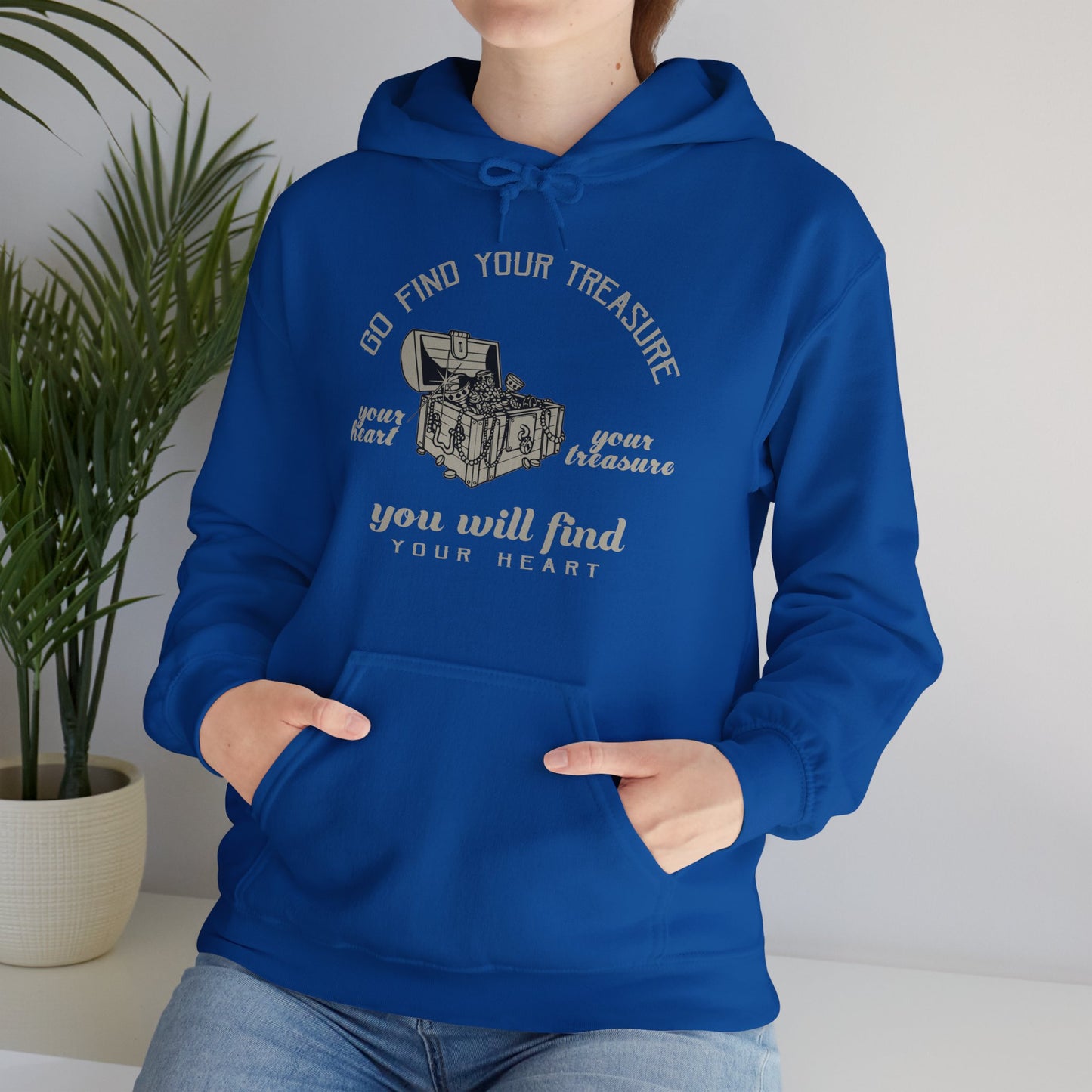 Person wearing a blue unisex hooded sweatshirt with 'Go Find Your Treasure You Will Find Your Heart' printed on the front.