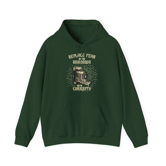 A green unisex hooded sweatshirt with 'REPLACE FEAR OF THE UNKNOWN WITH CURIOSITY' printed on the front.