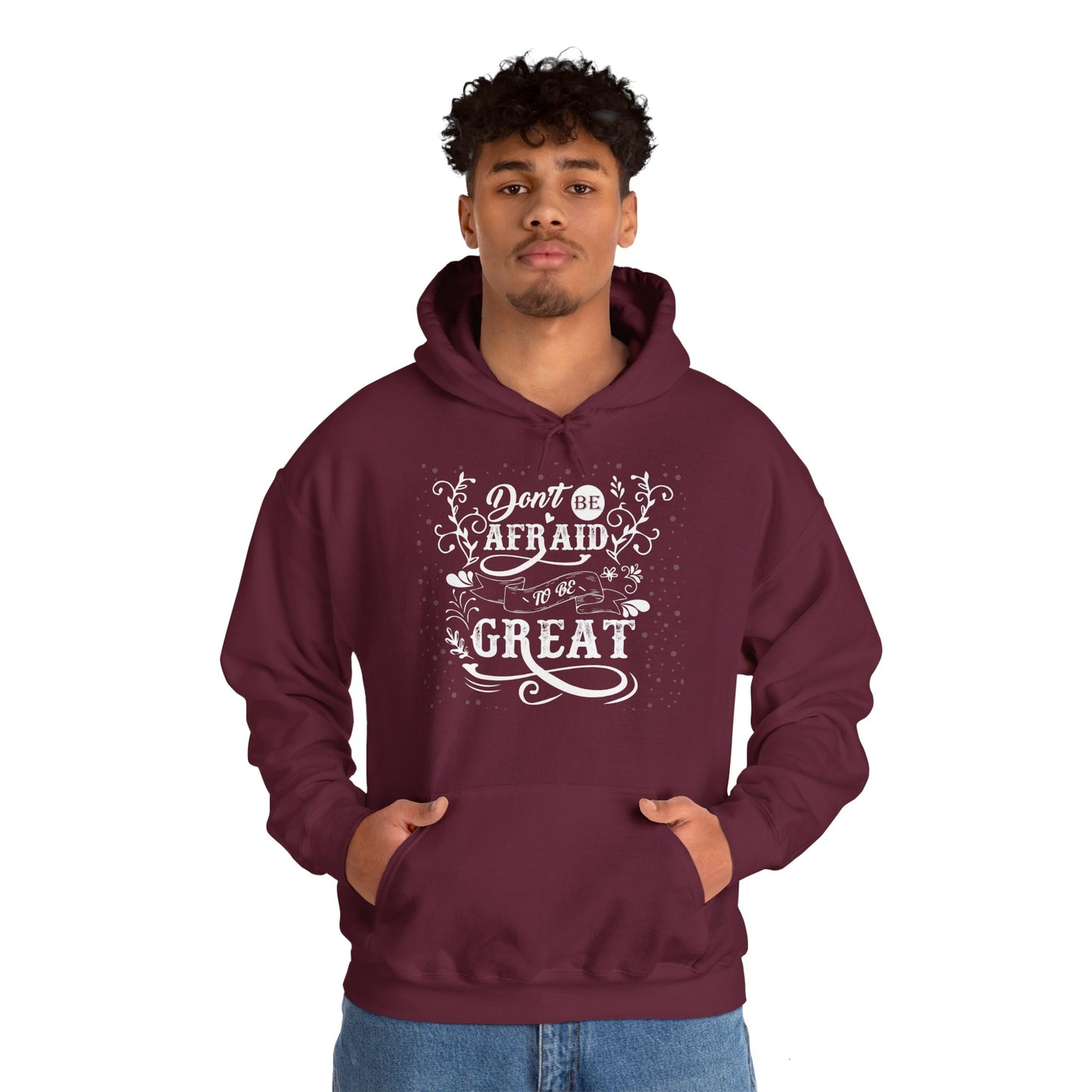 Person wearing a maroon unisex hooded sweatshirt with the text 'DON'T BE AFRAID TO BE GREAT' printed on the front.