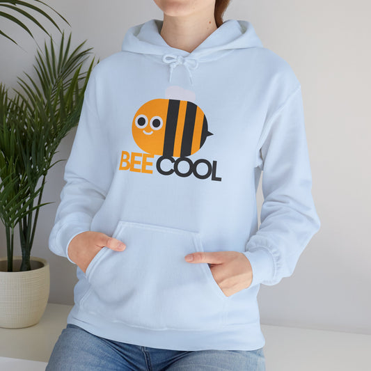 A person wearing a light blue unisex hooded sweatshirt with 'BEE COOL' text and a cartoon bee design on the front.