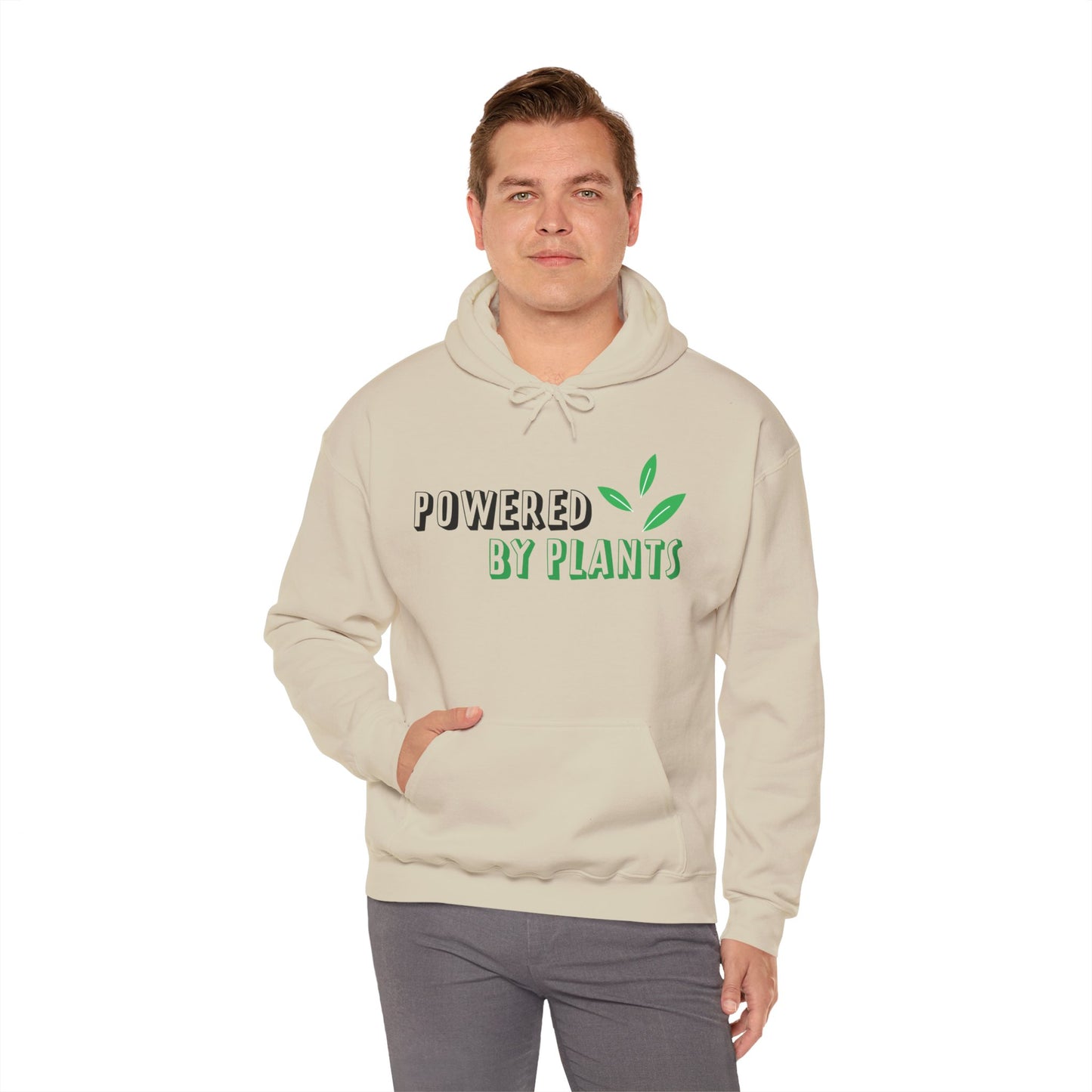 A person wearing a beige unisex hooded sweatshirt with 'Powered By Plants' text in green on the front.