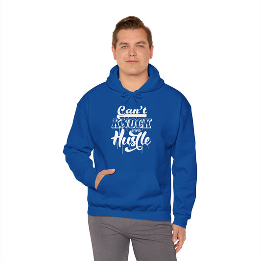 A person wearing a blue unisex hooded sweatshirt with 'Can't Knock The Hustle' text design.