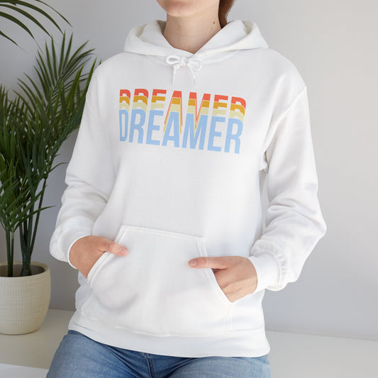 A person wearing a white unisex hooded sweatshirt with 'DREAMER' text in white and blue gradient on the front.